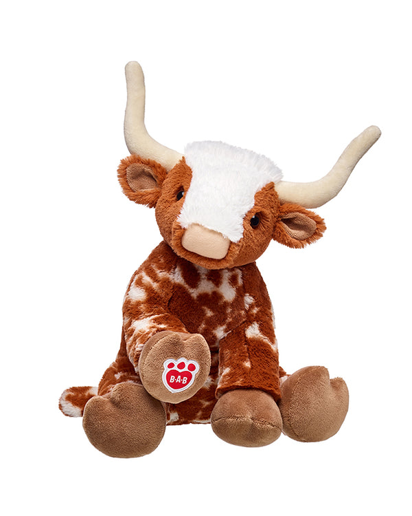 A stuffed animal longhorn sitting against a plain background, with large horns and a red paw print logo reading "B-A-B" in the center.