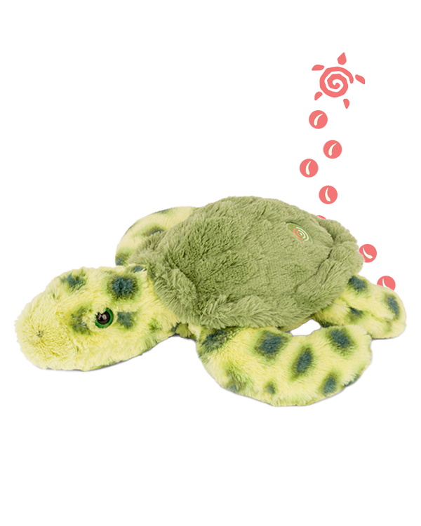 A green turtle plush toy with dark green spots on the body and green eyes laying against a plain background. There is also an illustration of a small pink turtle with circles trailing behind it on the right side of the image.