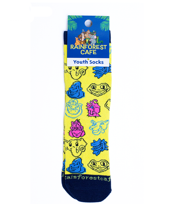 A pair of yellow socks featuring pixelated cartoon animal faces in different colors. The toe area reads "RAINFOREST CAFE" at the top. The socks are attached to a blue square tag with plants and jungle animals on it reading "RAINFOREST CAFE YOUTH SOCKS". The background is plain white.