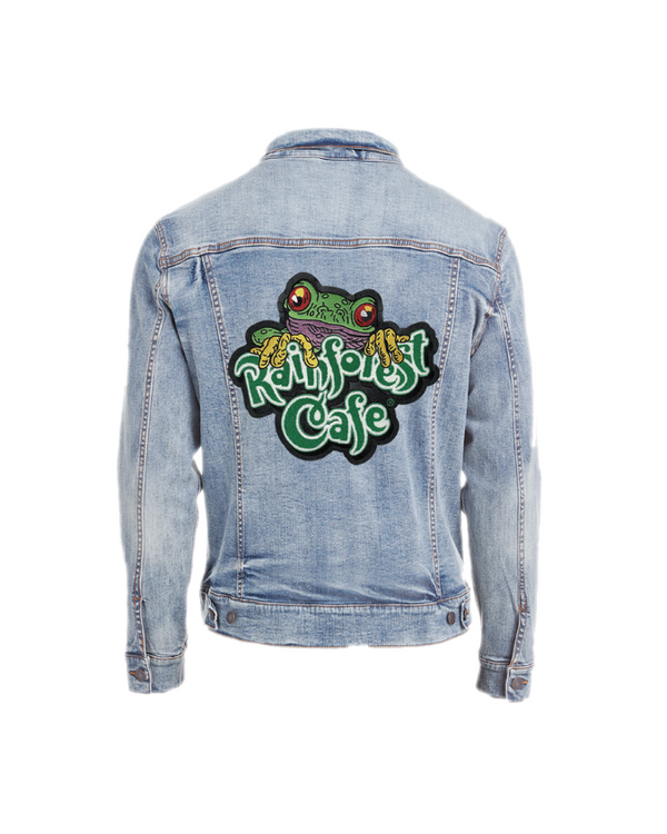 A backside view of a denim jacket with a green embroidered "RAINFOREST CAFE" logo patch with a tree frog over the wording. The background is plain white.