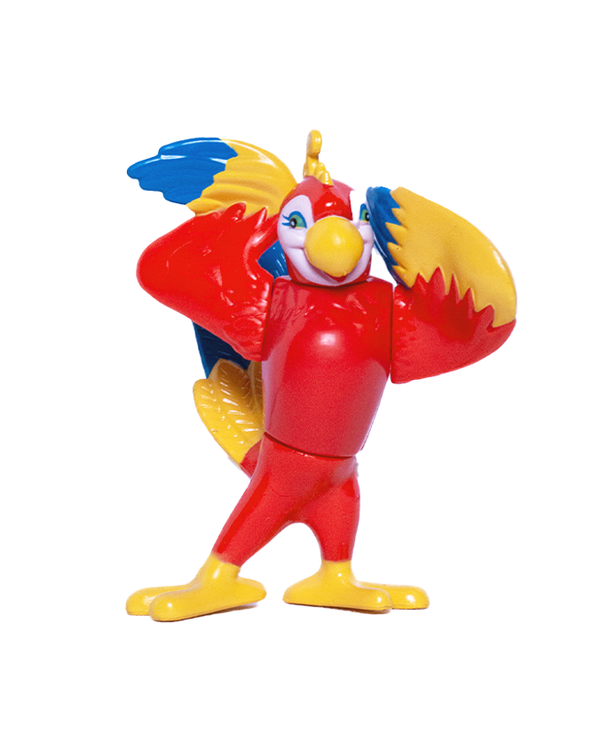 A red macaw figurine with her wings up to her head, and blue eyelashes, standing in front of a white backdrop.