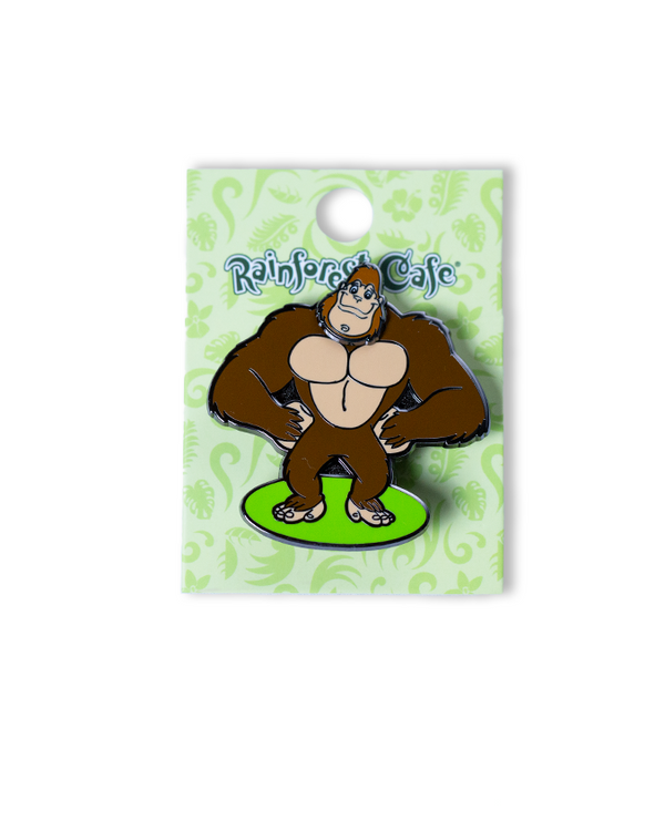A gorilla pin on a green circle with his hands on his hips, placed on a green card with "RAINFOREST CAFE" on the top. The background is plain white, featuring a rainbow ‘30 WILD YEARS!’ logo featuring CHA! CHA!.