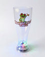 A clear plastic pint glass with a printed green frog and 'Rainforest Cafe' logo on the front, illuminated from within at the base with multicolor LED lights, set against a plain white background.