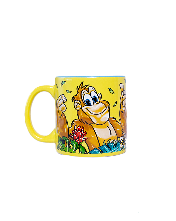 A colorful green mug with a posing monkey surrounded by tropical flowers and leaves. 