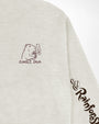 Close-up of a light heather gray sweatshirt showing the chest graphic with a capybara holding a coffee cup and the text 'JUNGLE JAVA', plus a dark script logo on the sleeve.