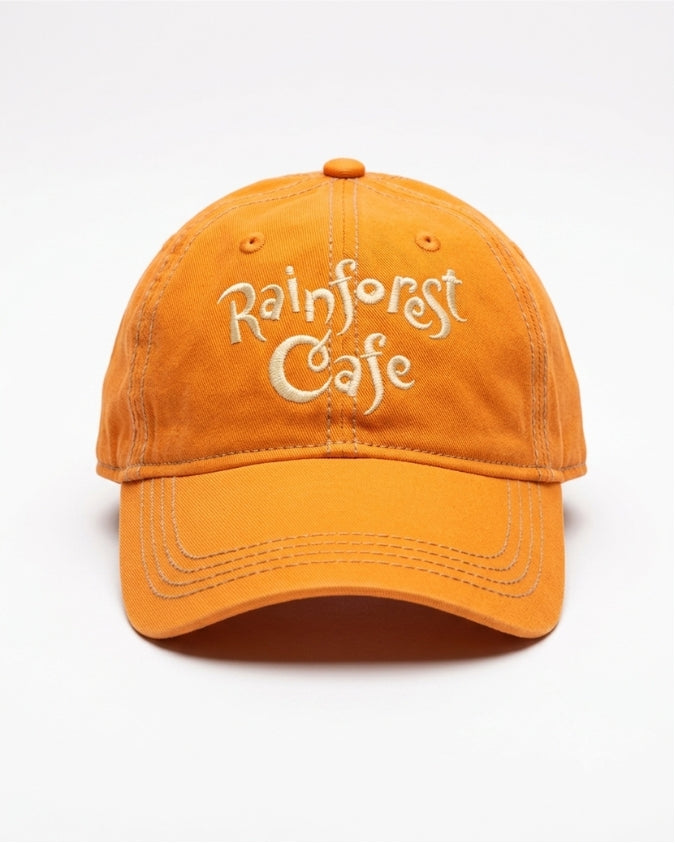 An orange cotton baseball cap with 'Rainforest Cafe' embroidered in white script on the front, shown against a plain white background.