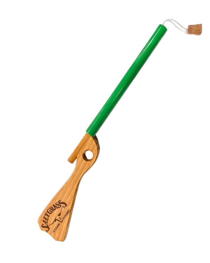 Green and wooden tool with cork end on a white background