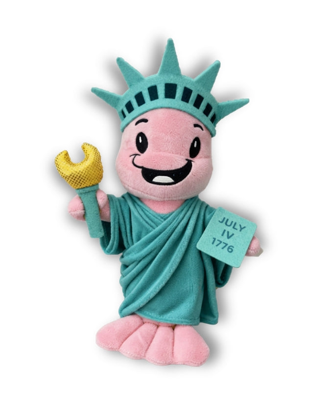 A plush toy shaped like a Bubba Gump Shrimp Louis in Statue of Liberty outfit with a pink face and hands, teal crown and robe, and a yellow wrench, shown on a white background with a soft shadow.