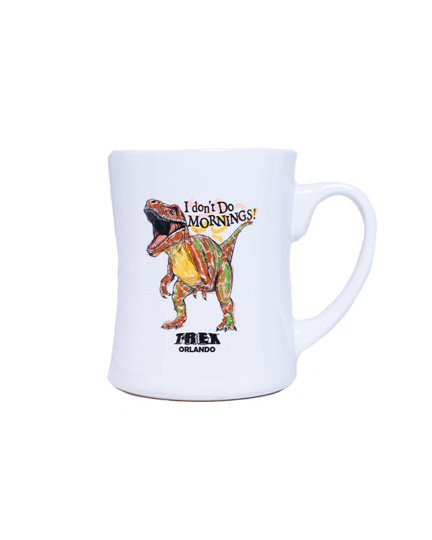 A white mug with a colorful print of a T-Rex dinosaur. Above the dinosaur, text reads ‘I don’t do MORNINGS!’ and below it, ‘TREX ORLANDO.’ The mug has a unique curved shape, wider at the top than the bottom, with a large handle on one side.