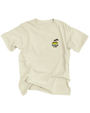 A full view of a beige-colored T-shirt with a small graphic design on the left chest area featuring two palm trees, a relaxing laying frog, and the text "Rainforest Cafe" written in a stylized font. The background is plain white.