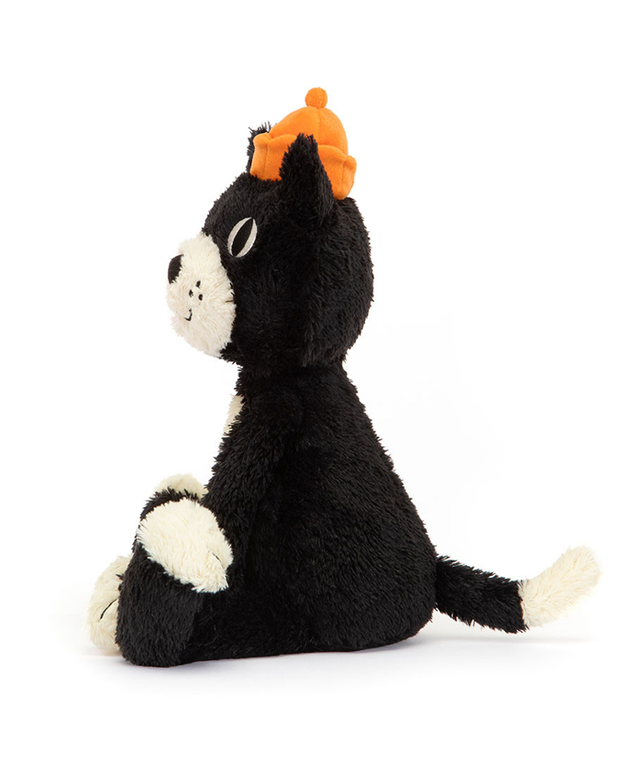 A sideview of a black cat plush sitting against a white background, with a white belly and snout, and an orange beanie hat.