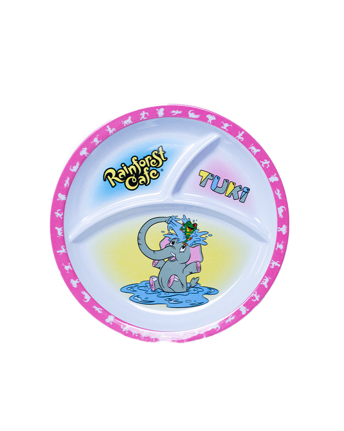 A colorful plate featuring a design with a pink border containing small stars and the words ‘Rainforest Cafe’ in a playful, green font. The center of the plate shows an illustration of a cartoon elephant named Tuki, who is sitting in water and splashing it to cha cha who is on top of it's head.