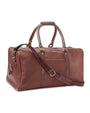 A brown leather duffel bag featuring two handles and a detachable padded strap with an illegible embossed design. The bag includes gold-colored hardware, and an oval patch at the top. The background is plain white.