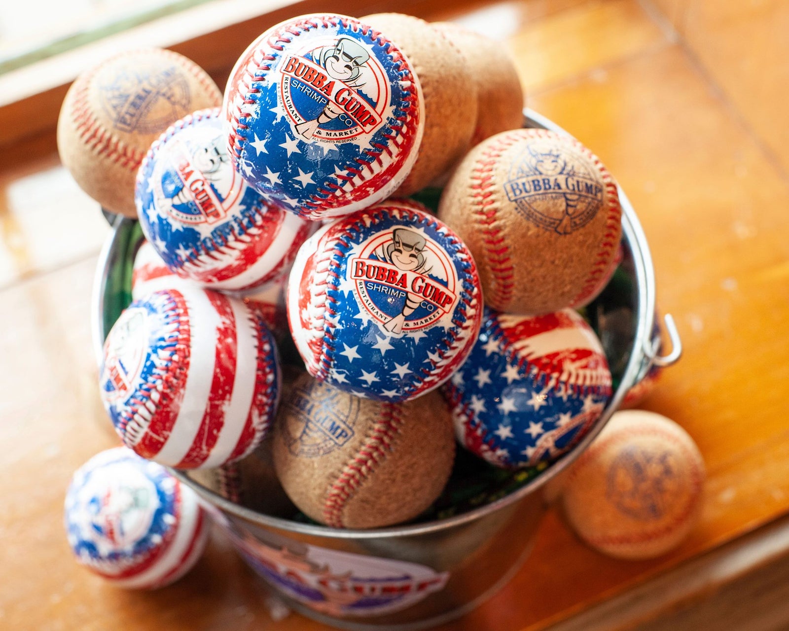Cork baseballs with Blue Bubba Gump Logo, and American Flag print baseballs with Bubba Gump logo in a tin.